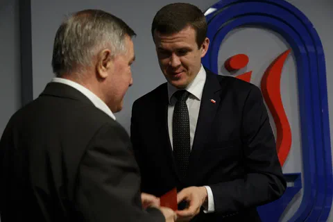 Przekazanie odznaczenia w etui wyróżnionemu pracownikowi podczas uroczystości.