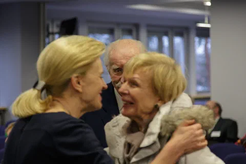 Powitanie i rozmowa gości w kuluarach spotkania jubileuszowego.