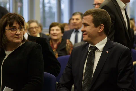 Goście zajmujący miejsca w pierwszym rzędzie sali konferencyjnej.