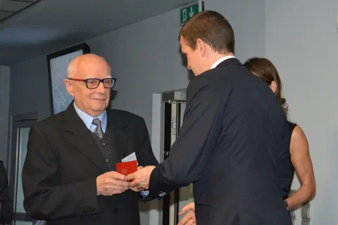 Wręczenie odznaczenia w etui mężczyźnie w okularach.