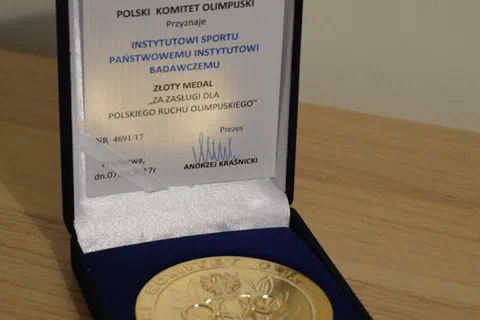 Złoty medal od Polskiego Komitetu Olimpijskiego z tabliczką dedykacyjną w otwartym etui.
