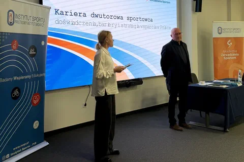 Dwoje prowadzących stojących przy ekranie z tytułem szkolenia o karierze dwutorowej sportowca.