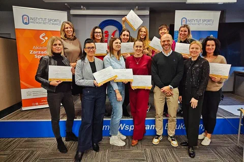 Grupowe zdjęcie uczestniczek prezentujących certyfikaty ukończenia cyklu szkoleń wraz z prowadzącym.