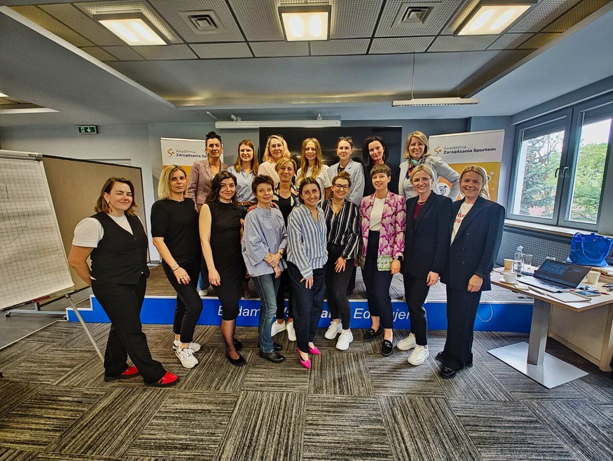 Grupowe zdjęcie uczestniczek inauguracyjnego szkolenia projektu „Liderki w sporcie” na tle ścianki Instytutu Sportu – PIB.