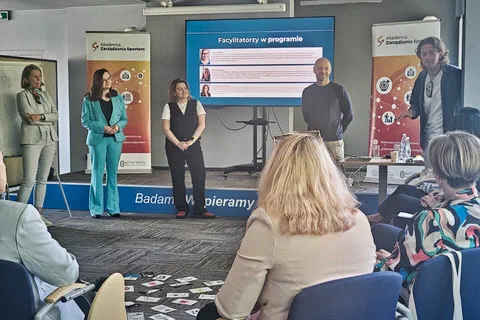 Prezentacja sylwetek facylitatorów programu na ekranie przed uczestniczkami siedzącymi w sali.