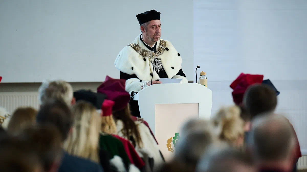 JM Rektor AWF Warszawa prof. Bartosz Molik w stroju rektorskim przemawiający z mównicy podczas inauguracji roku akademickiego 2026/2027.