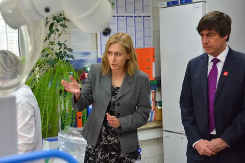 Rozmowa w pracowni laboratoryjnej przy stanowisku badawczym.