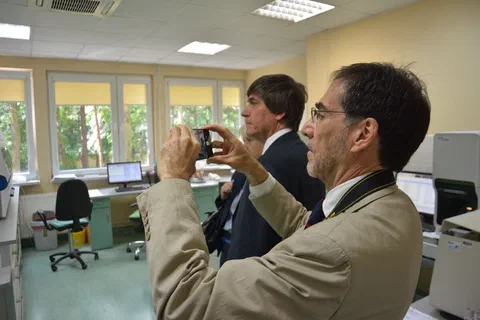 Gość fotografujący telefonem wyposażenie pracowni podczas wizyty w laboratorium.