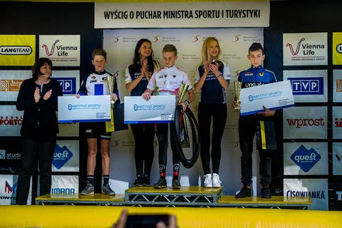 Kolejna trójka kolarzy w kategorii młodzieżowej udekorowana na podium wyścigu.