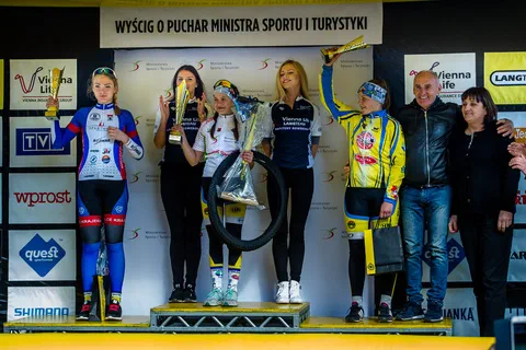 Zawodniczki na podium unoszące puchary podczas ceremonii wręczenia nagród.