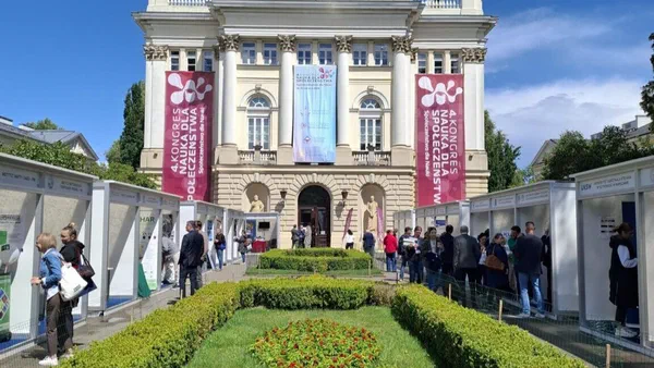 Stoiska wystawiennicze przed gmachem Starego BUW na kampusie Uniwersytetu Warszawskiego z banerami 4. Kongresu „Nauka dla Społeczeństwa”.