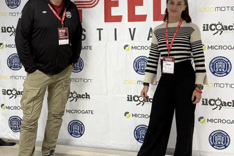 Dwoje uczestników konferencji z identyfikatorami stojących na tle ścianki SpeedFestival 2025.