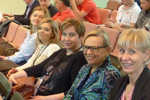 Cztery uczestniczki konferencji siedzące obok siebie na widowni.