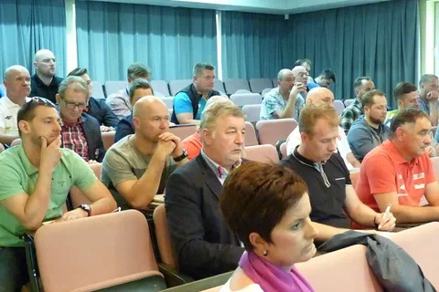 Słuchacze zgromadzeni w środkowej części sali konferencyjnej.