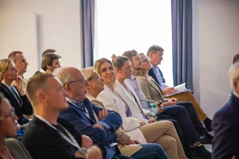 Uczestnicy konferencji siedzący w pierwszym rzędzie widowni.
