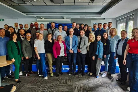 Zdjęcie grupowe uczestników drugiego dnia warsztatów stojących w sali konferencyjnej Instytutu