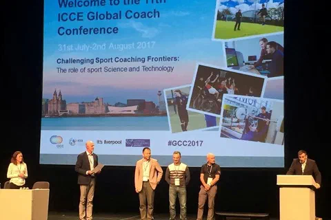 Panel dyskusyjny z udziałem pięciu osób na scenie pod ekranem głównym konferencji w Liverpoolu