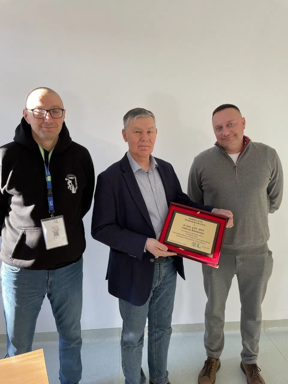 Dr hab. Andrzej Klusiewicz (w środku) trzymający pamiątkowe podziękowanie w otoczeniu dwóch organizatorów warsztatów