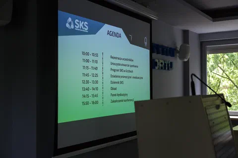 Ekran projekcyjny z agendą konferencji programu Szkolny Klub Sportowy i godzinowym planem spotkań