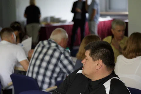 Uczestnicy rozmawiający przy stołach podczas przerwy w obradach