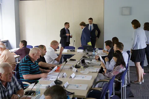 Widok wzdłuż długiego stołu konferencyjnego na salę podczas rozmów kuluarowych