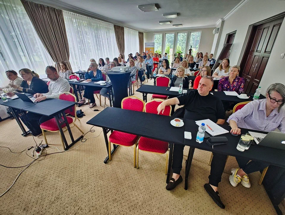 Widok na salę szkoleniową z uczestnikami warsztatów dla księgowych związków sportowych siedzącymi przy stołach