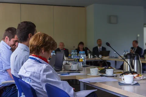 Uczestnicy posiedzenia widziani z boku stołu podczas prezentacji i dyskusji