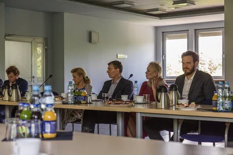 Czworo uczestników obrad siedzących przy bocznym skrzydle stołu konferencyjnego