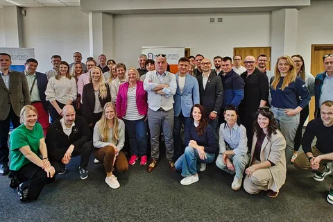 Wspólne zdjęcie uczestników szkolenia i prowadzących ustawionych w dwóch rzędach w sali konferencyjnej