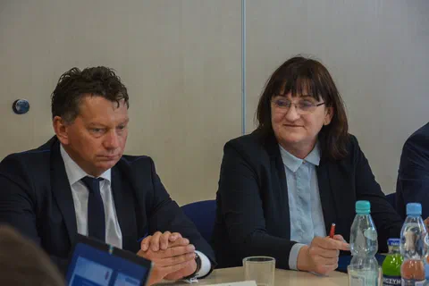 Zbliżenie na mężczyznę i kobietę podpisujących dokumenty przy stole konferencyjnym