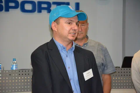 Zbliżenie na prowadzącego w marynarce i niebieskiej czapce z daszkiem podczas objaśniania ćwiczenia