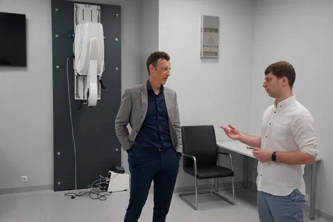 Rozmowa dwóch mężczyzn w pracowni diagnostycznej obok stanowiska pomiarowego
