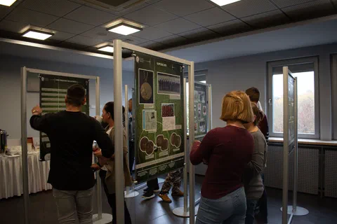 Zwiedzający oglądający ekspozycję planszową ustawioną na stelażach w sali Instytutu
