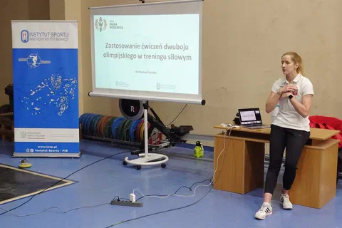 Prelegentka prowadząca wykład o zastosowaniu ćwiczeń dwuboju olimpijskiego w treningu siłowym